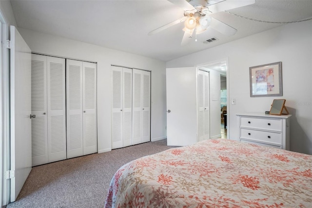 bedroom with multiple closets, ceiling fan, and light colored carpet