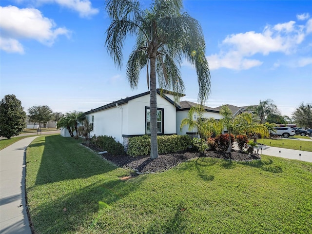 view of side of home with a yard