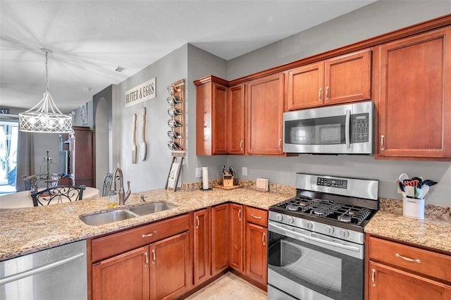 kitchen with sink, light stone counters, decorative light fixtures, light tile patterned floors, and appliances with stainless steel finishes