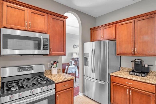 kitchen featuring stainless steel appliances and light stone counters