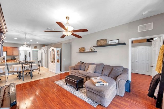 living room with ceiling fan and light wood-type flooring