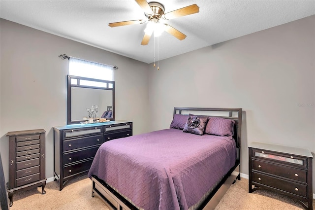 bedroom featuring ceiling fan, light carpet, and a textured ceiling