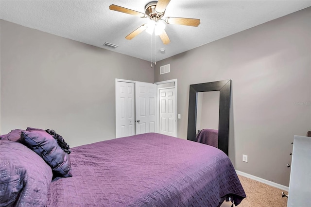 carpeted bedroom featuring ceiling fan, a closet, and a textured ceiling