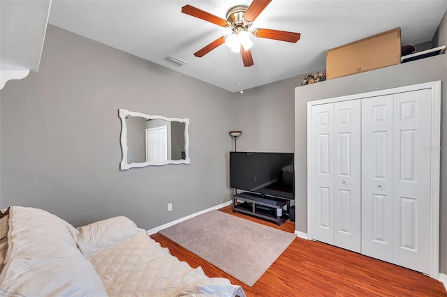 living room with ceiling fan, hardwood / wood-style flooring, and a textured ceiling