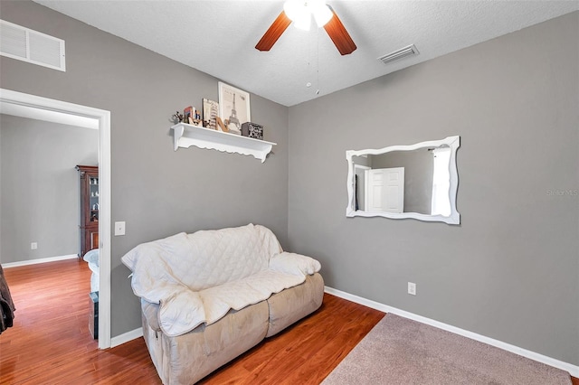 sitting room featuring hardwood / wood-style floors, a textured ceiling, and ceiling fan