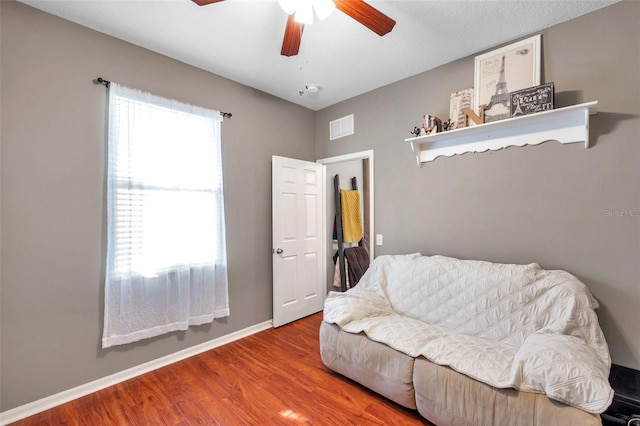 living area featuring hardwood / wood-style floors and ceiling fan