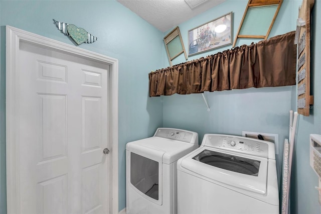 clothes washing area with independent washer and dryer and a textured ceiling