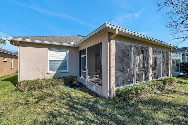 view of side of home with a yard and a sunroom