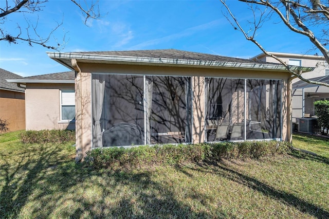 rear view of property with a sunroom, a yard, and cooling unit