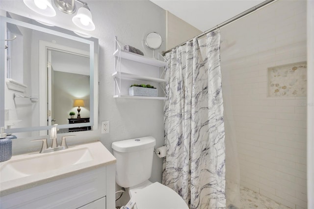 bathroom featuring walk in shower, vanity, and toilet