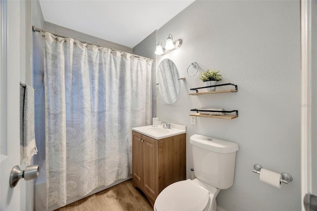 bathroom featuring hardwood / wood-style flooring, vanity, toilet, and curtained shower