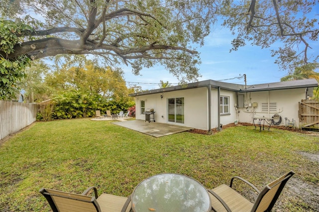 rear view of property featuring a patio and a lawn