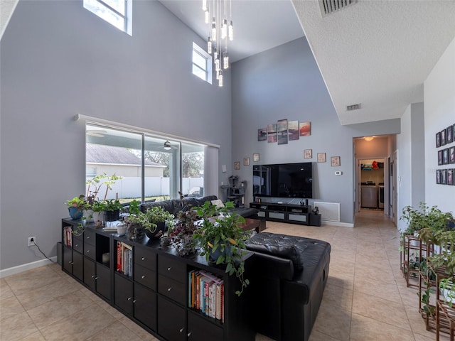 tiled living room featuring a textured ceiling and a high ceiling