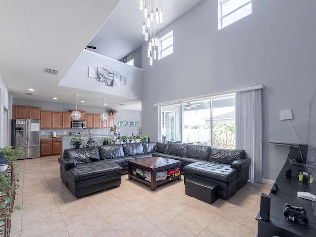 living room with light tile patterned flooring, a high ceiling, and a wealth of natural light