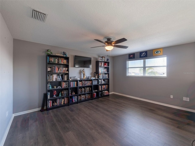 spare room with ceiling fan, a textured ceiling, and dark hardwood / wood-style flooring