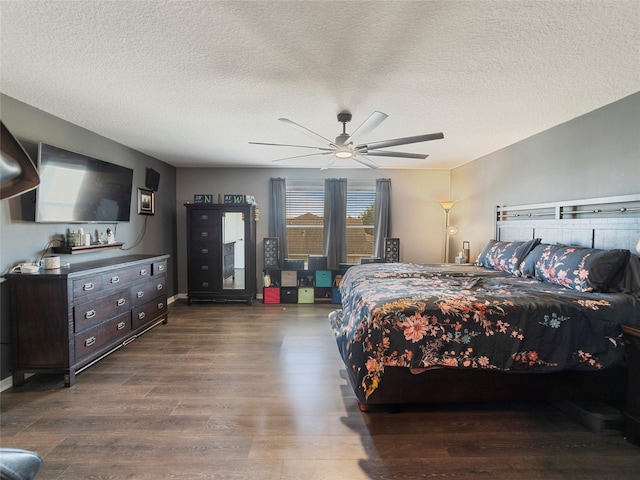 bedroom with a textured ceiling, dark hardwood / wood-style floors, and ceiling fan