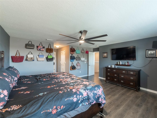 bedroom featuring dark hardwood / wood-style flooring, a textured ceiling, and ceiling fan