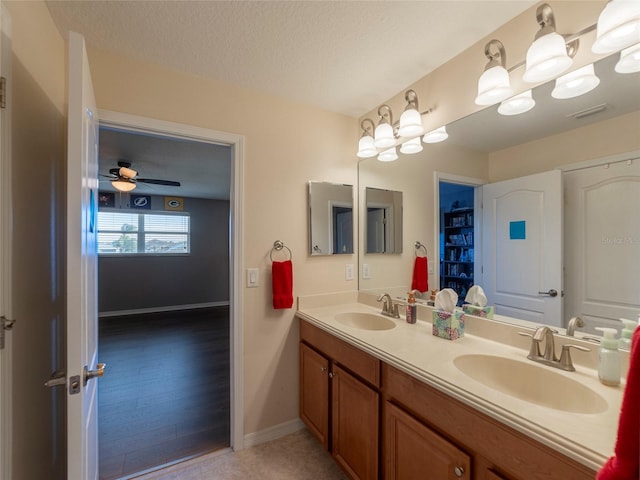 bathroom featuring vanity, ceiling fan, and a textured ceiling