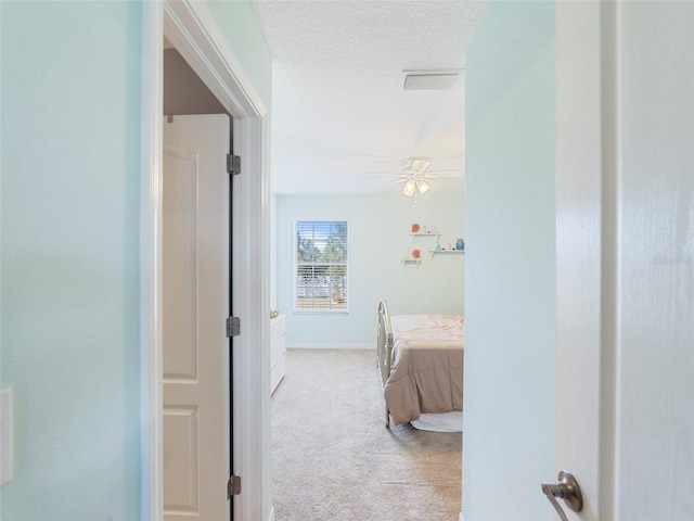 interior space featuring light carpet and a textured ceiling