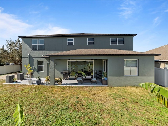 back of property with central AC, a yard, and a patio area