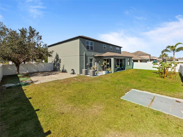 rear view of house with a lawn and a patio