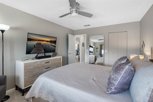 bedroom with visible vents, baseboards, light colored carpet, ceiling fan, and a closet