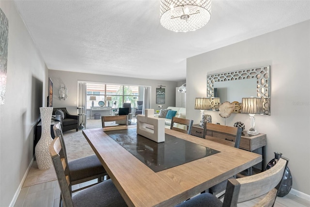 dining space with baseboards and a textured ceiling