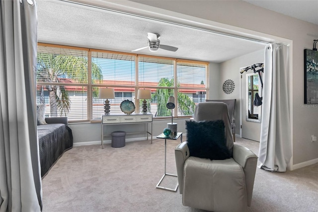 interior space featuring a ceiling fan, carpet flooring, a textured ceiling, and baseboards