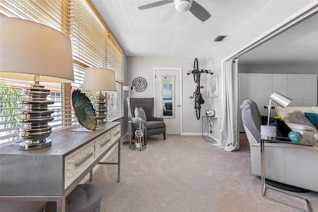 interior space with baseboards, visible vents, ceiling fan, carpet, and a textured ceiling