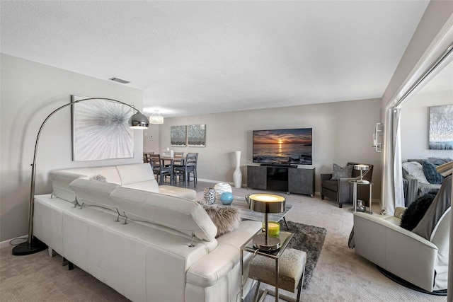 carpeted living room with baseboards, visible vents, and a textured ceiling