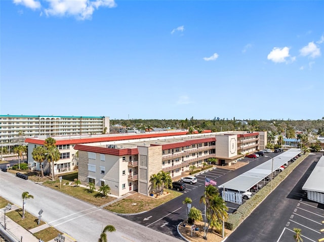 view of building exterior featuring uncovered parking and a city view