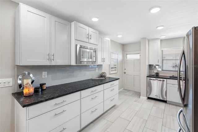 kitchen featuring white cabinets, baseboards, stainless steel appliances, and decorative backsplash