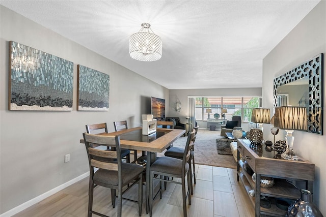 dining room with an inviting chandelier and baseboards