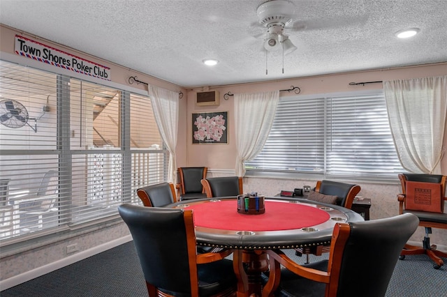 carpeted dining room with a textured ceiling, a ceiling fan, and baseboards