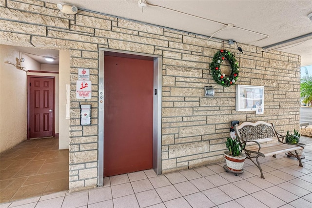 entrance to property with stone siding and elevator