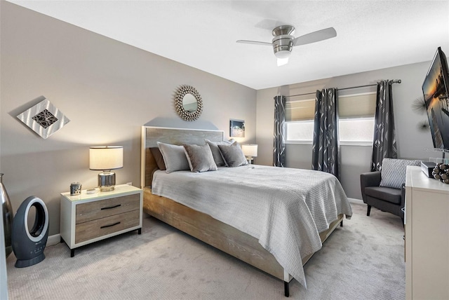 bedroom with light colored carpet, baseboards, and ceiling fan