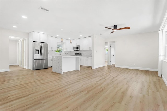 kitchen featuring white cabinetry, light hardwood / wood-style flooring, stainless steel appliances, and a center island