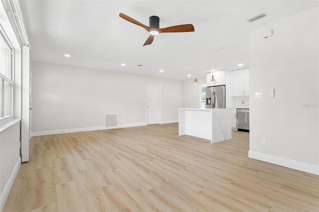 unfurnished living room with light hardwood / wood-style flooring and ceiling fan