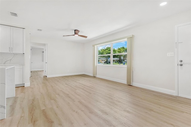 unfurnished living room with ceiling fan and light hardwood / wood-style floors