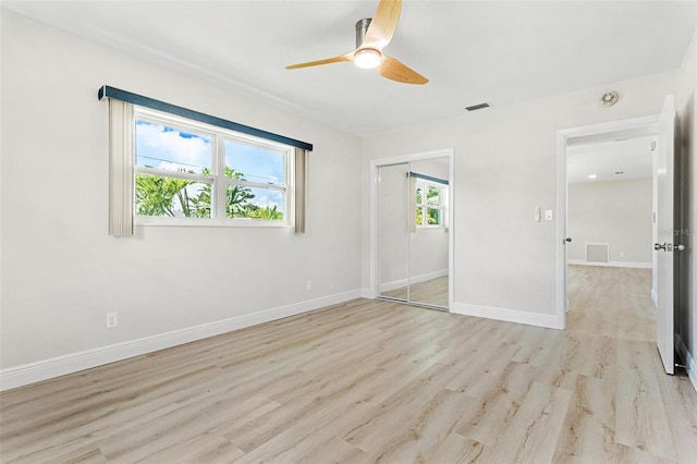 unfurnished bedroom with light hardwood / wood-style flooring, ceiling fan, and a closet