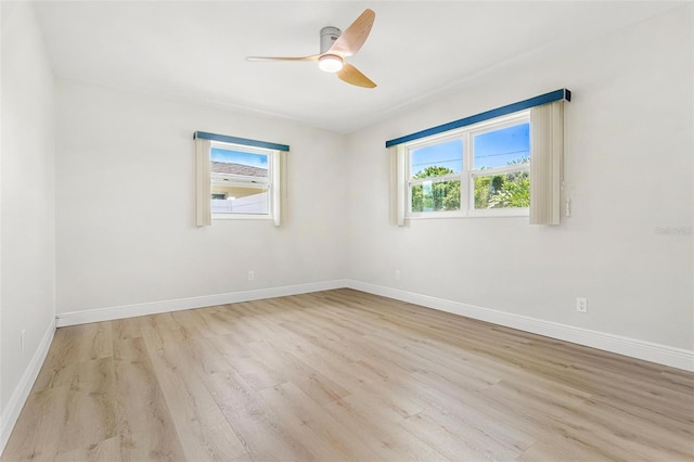 empty room with plenty of natural light, light hardwood / wood-style floors, and ceiling fan