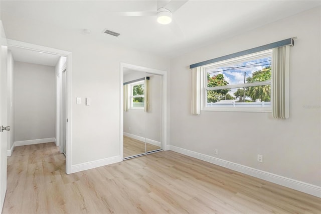 unfurnished bedroom featuring ceiling fan, light hardwood / wood-style floors, and a closet