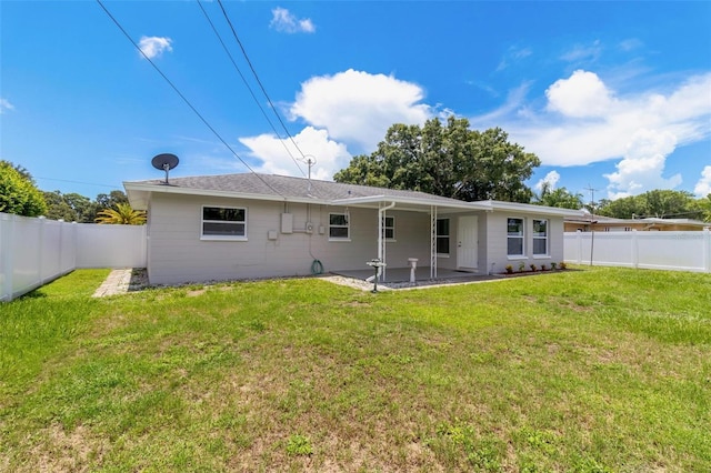 rear view of house featuring a patio and a yard