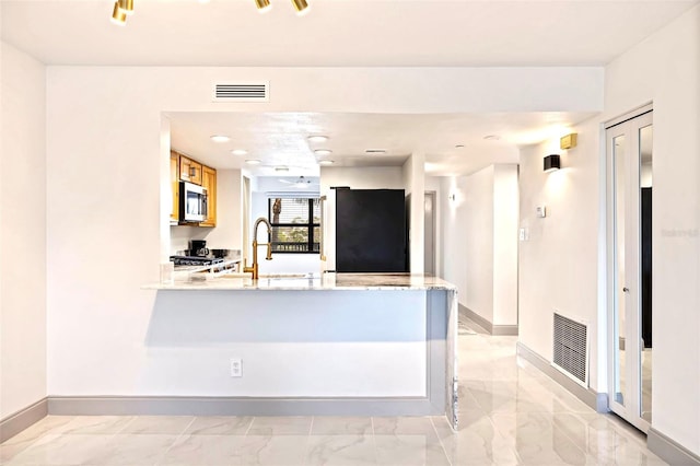 5400 Park St N Unit 209, Saint Petersburg, FL 33709 - kitchen featuring stainless steel microwave, fridge, baseboards, and light marble finish floors