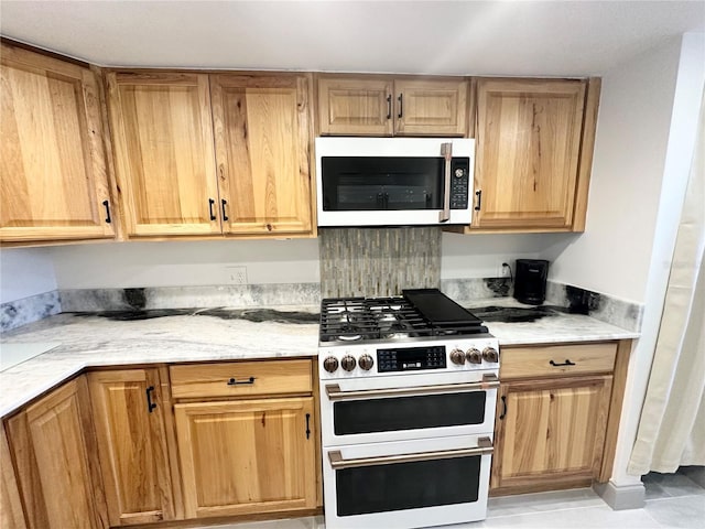 5400 Park St N Unit 209, Saint Petersburg, FL 33709 - kitchen with white appliances, light tile patterned floors, and light stone counters