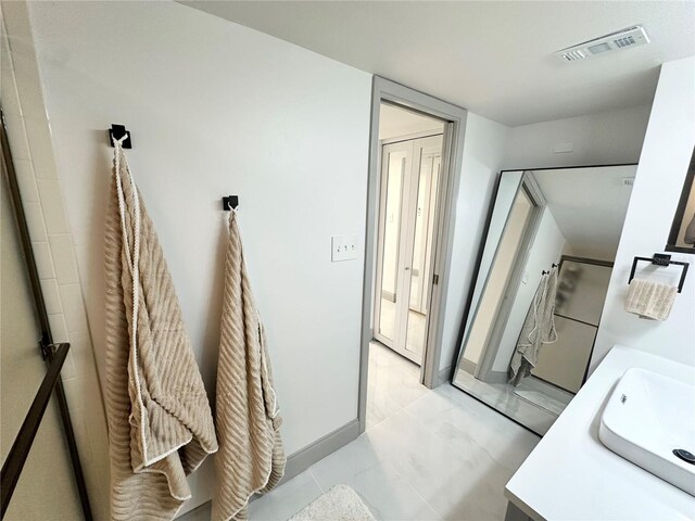 5400 Park St N Unit 209, Saint Petersburg, FL 33709 - bathroom with marble finish flooring, vanity, baseboards, and a shower