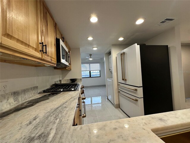 5400 Park St N Unit 209, Saint Petersburg, FL 33709 - kitchen featuring stainless steel appliances, brown cabinets, light tile patterned flooring, recessed lighting, and light countertops