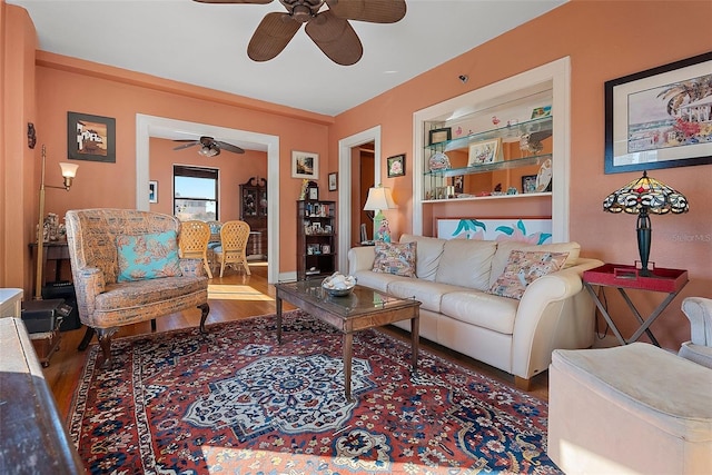 living room with dark wood-type flooring and ceiling fan