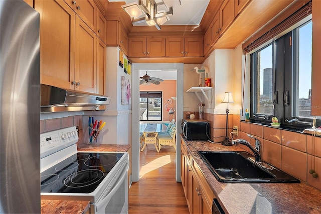 kitchen with sink, decorative backsplash, a wealth of natural light, and white electric stove