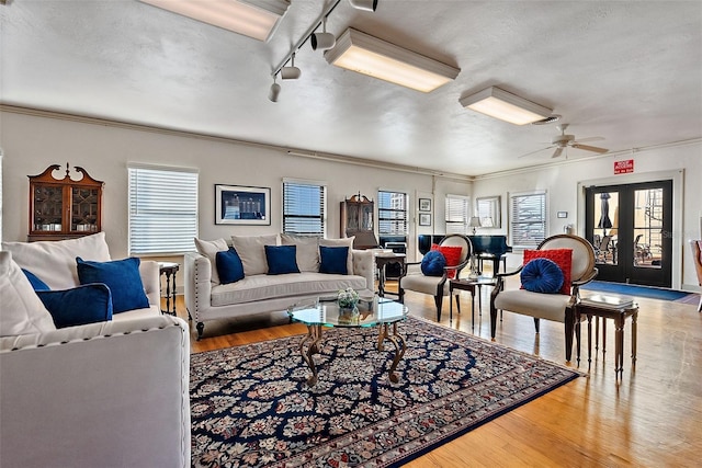 living room featuring crown molding, french doors, ceiling fan, and hardwood / wood-style flooring